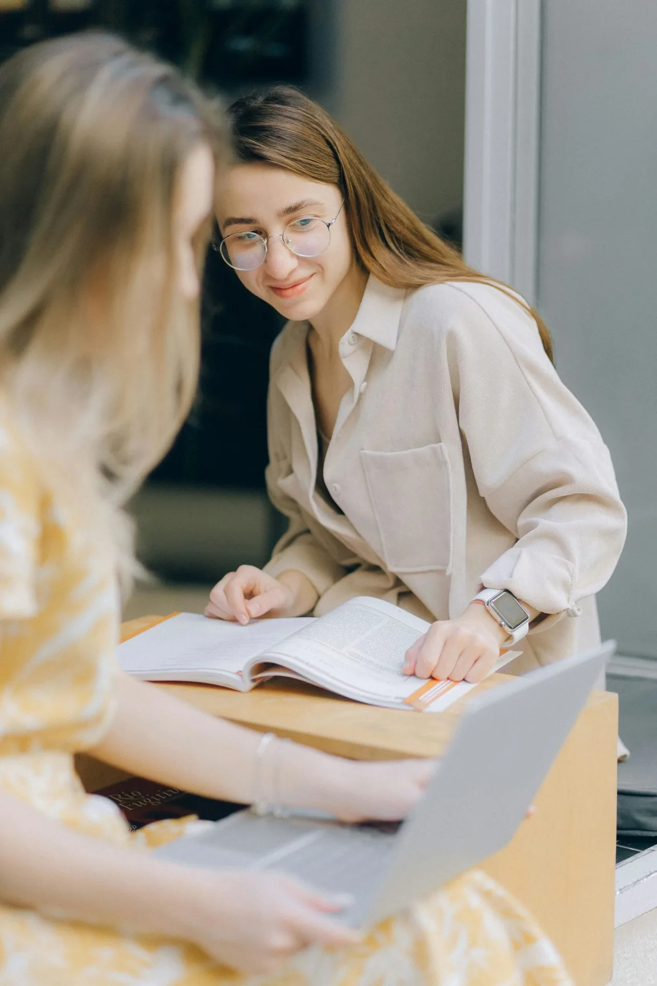 2 cô gái đang trao đổi làm việc cùng nhau