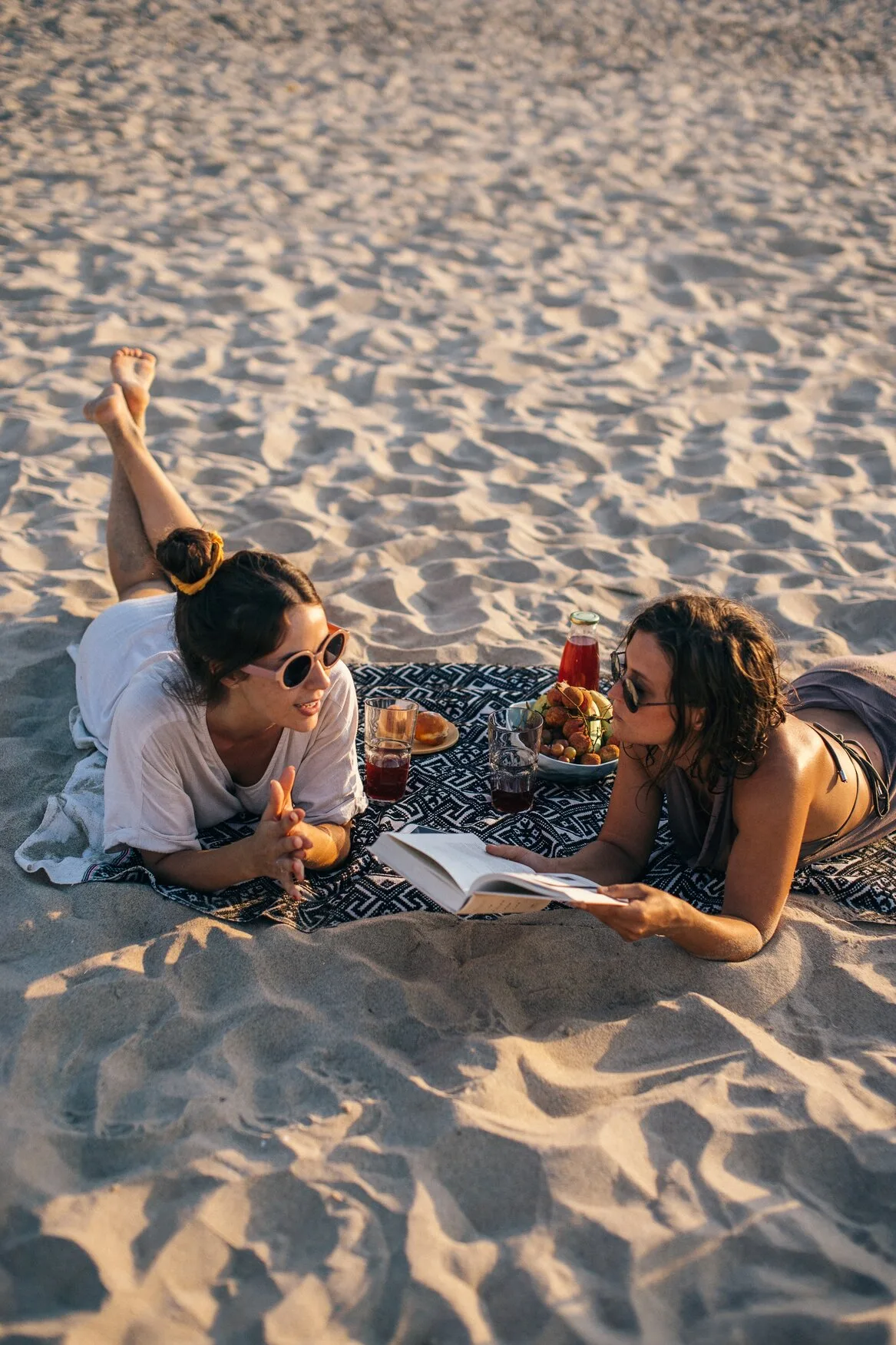 hai cô gái nằm bên bờ biển