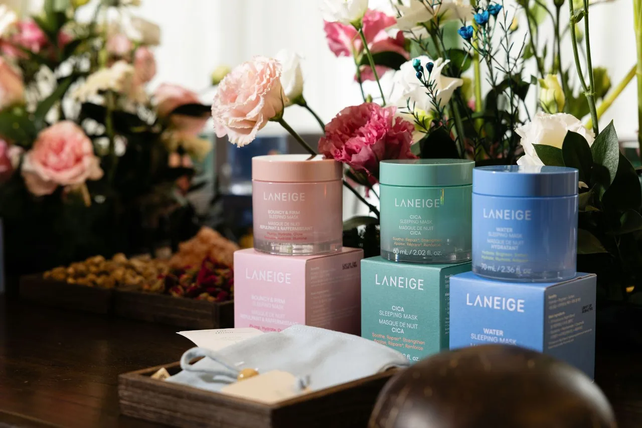 Bộ ba mặt nạ ngủ Laneige gồm Water Sleeping Mask, Cica Sleeping Mask và Bouncy & Firm Sleeping Mask trưng bày cùng hoa tươi.