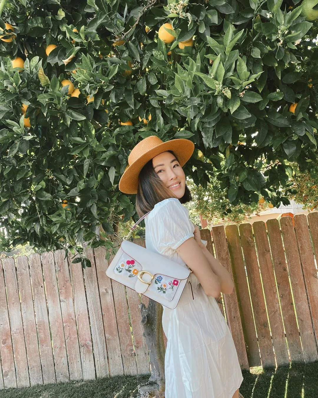 chrisellelim đeo túi xách coach màu trắng