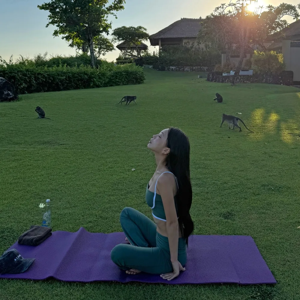 cô gái ngồi trên thảm tập ngoài trời