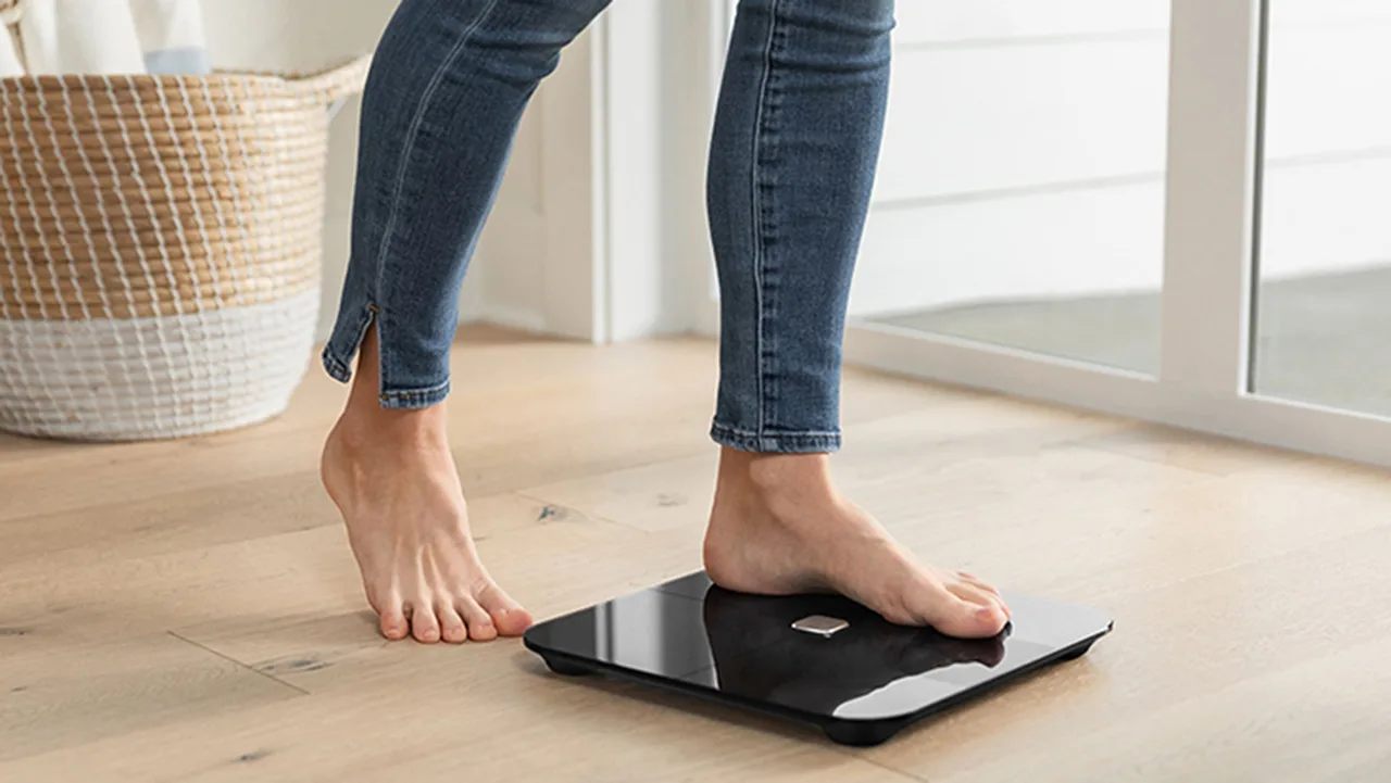 Phụ nữ bước lên cân để đo chỉ số BMI