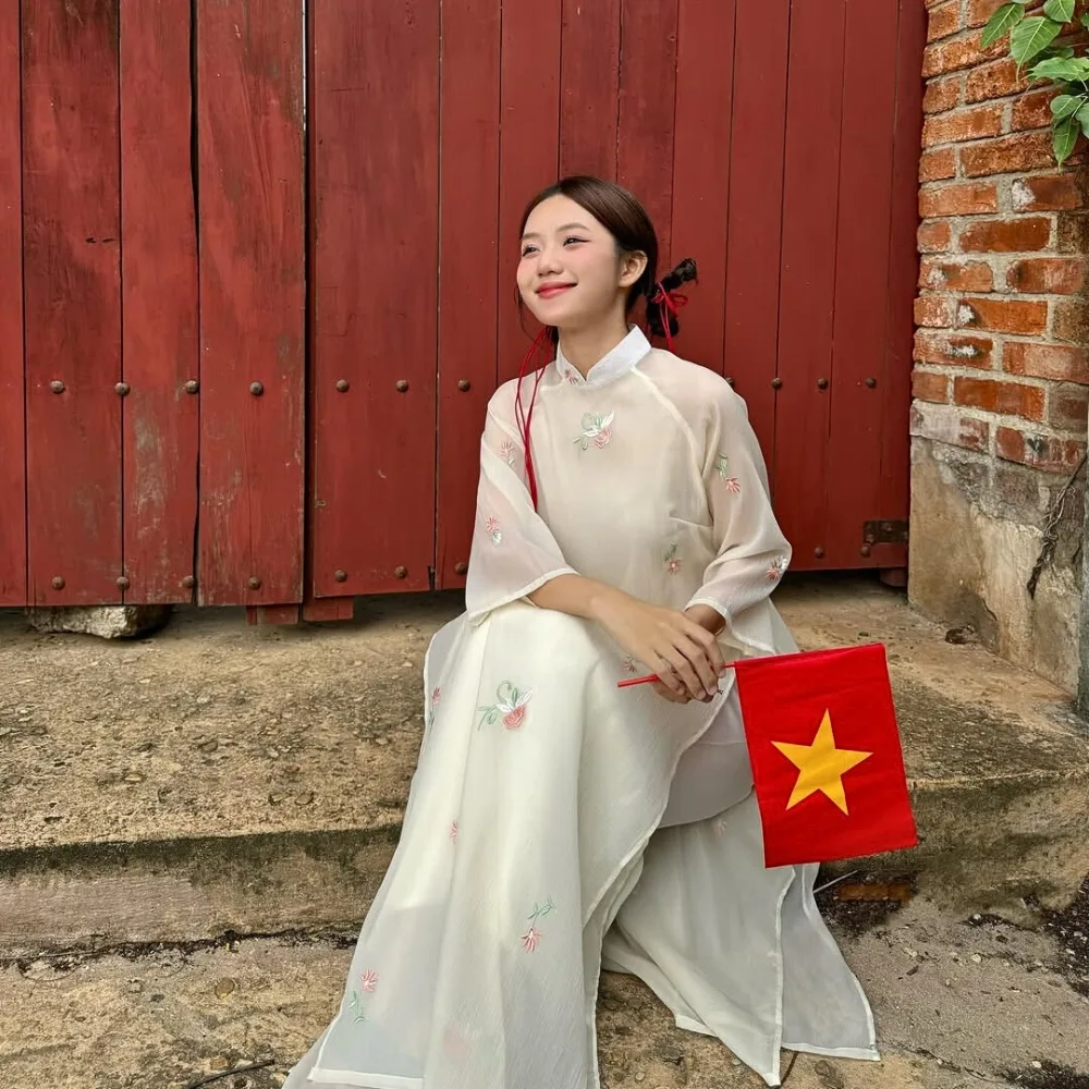 Cô gái tết tóc thành 2 búi thấp khi mang áo dài trắng