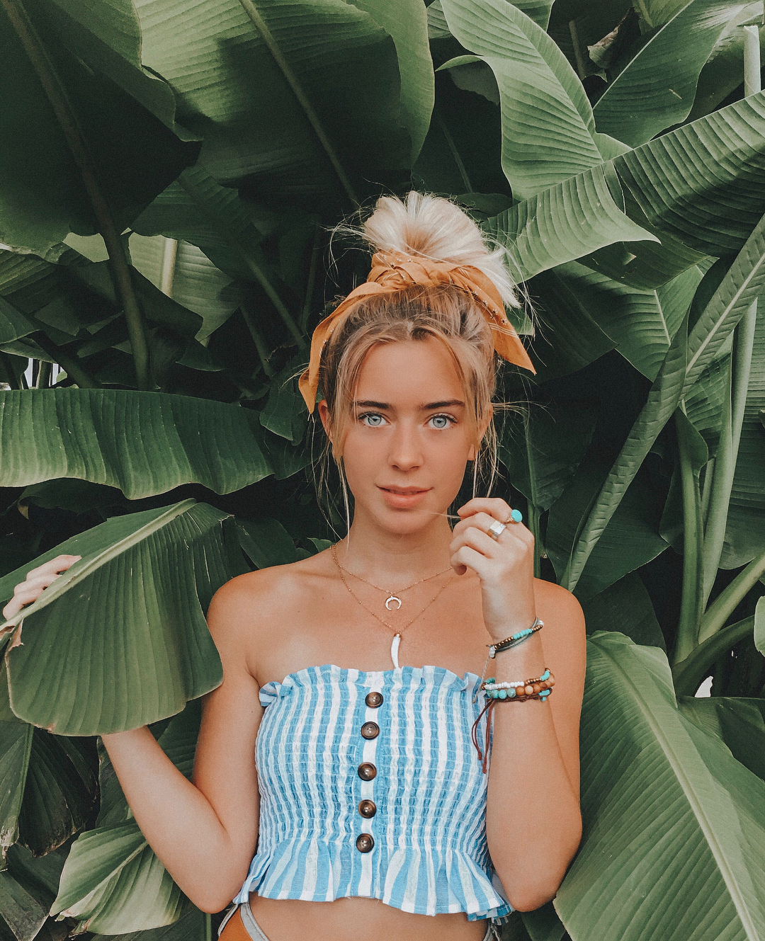 Cô gái mặc áo crop-top sọc, đeo vòng đeo tay đủ màu