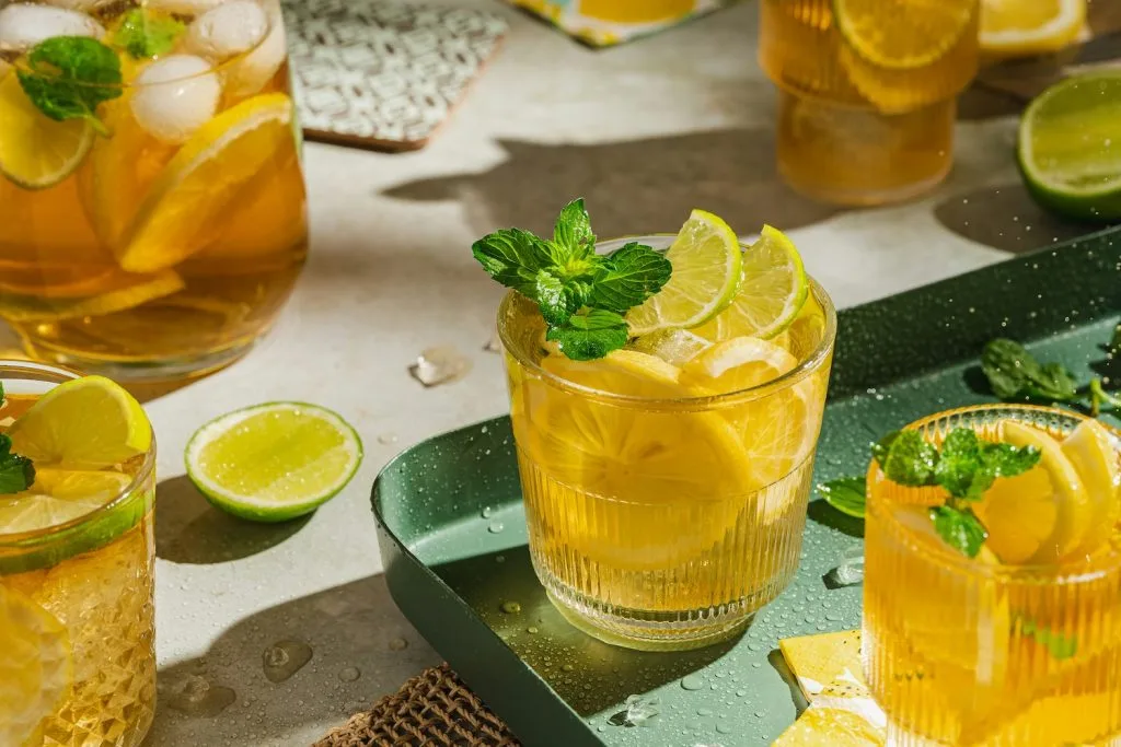 Ly nước chanh tươi mát với lát chanh và lá bạc hà trên bàn sáng.