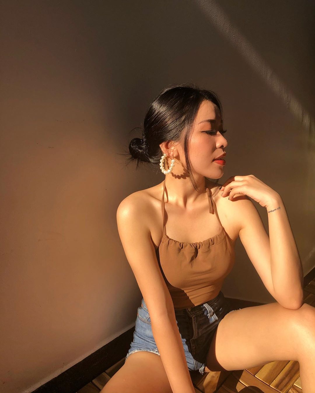 An Phương mặc áo yếm dây màu nâu