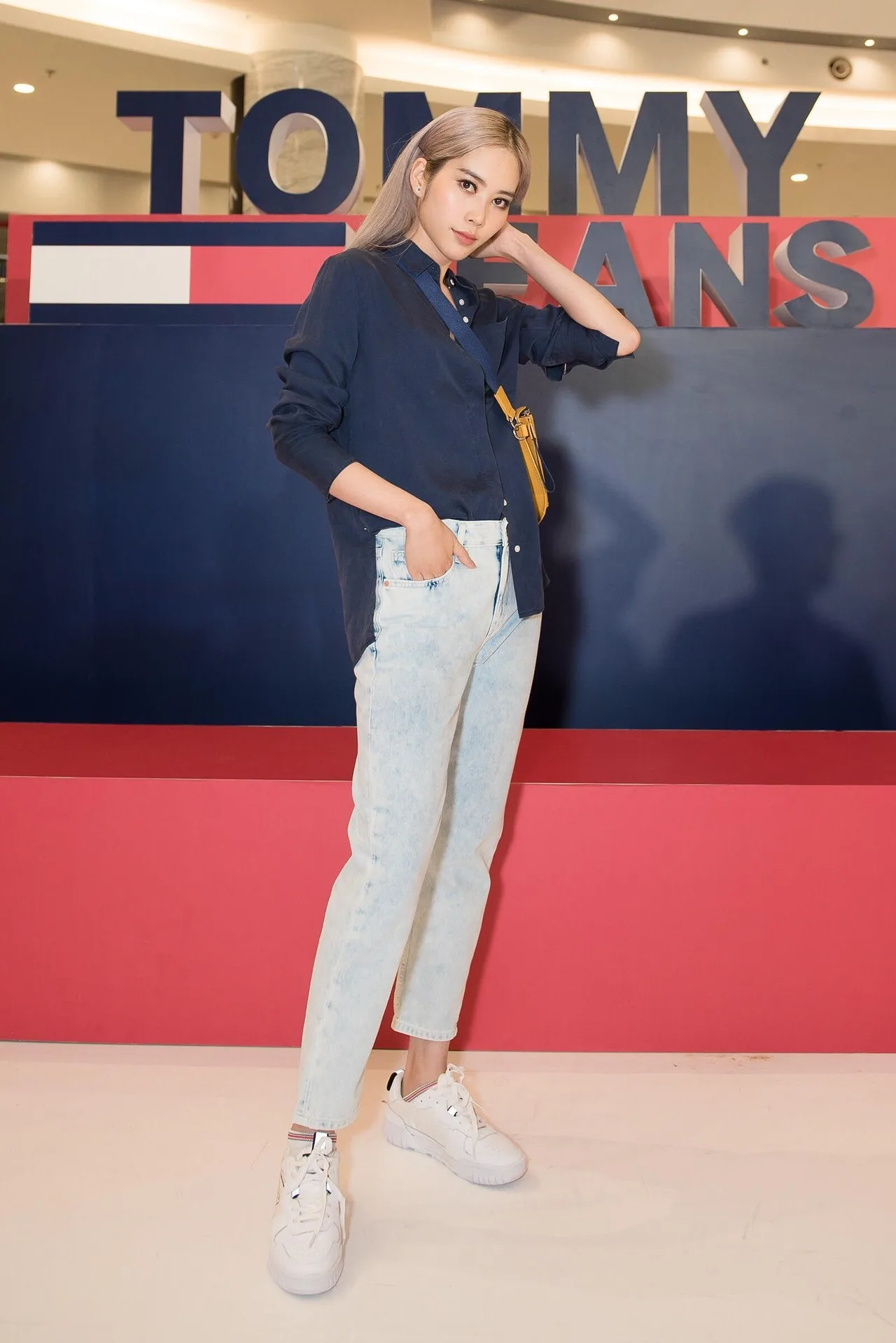 Hoa hậu Nam Em với phong cách trẻ trung năng động với gồm áo sơ mi, quần jeans, túi đeo chéo và giày sneaker.