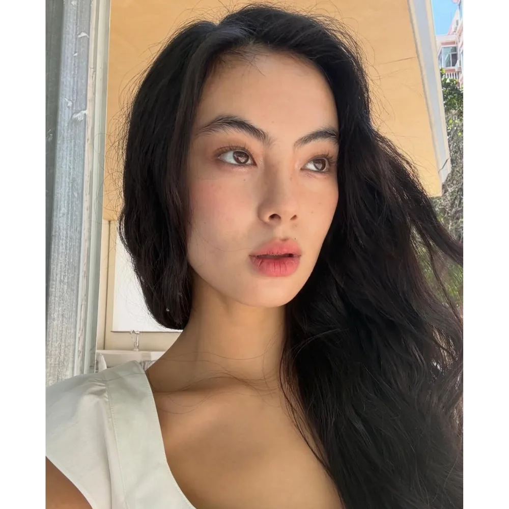 cô gái với mái tóc đen dài và trang điểm tone cam đào