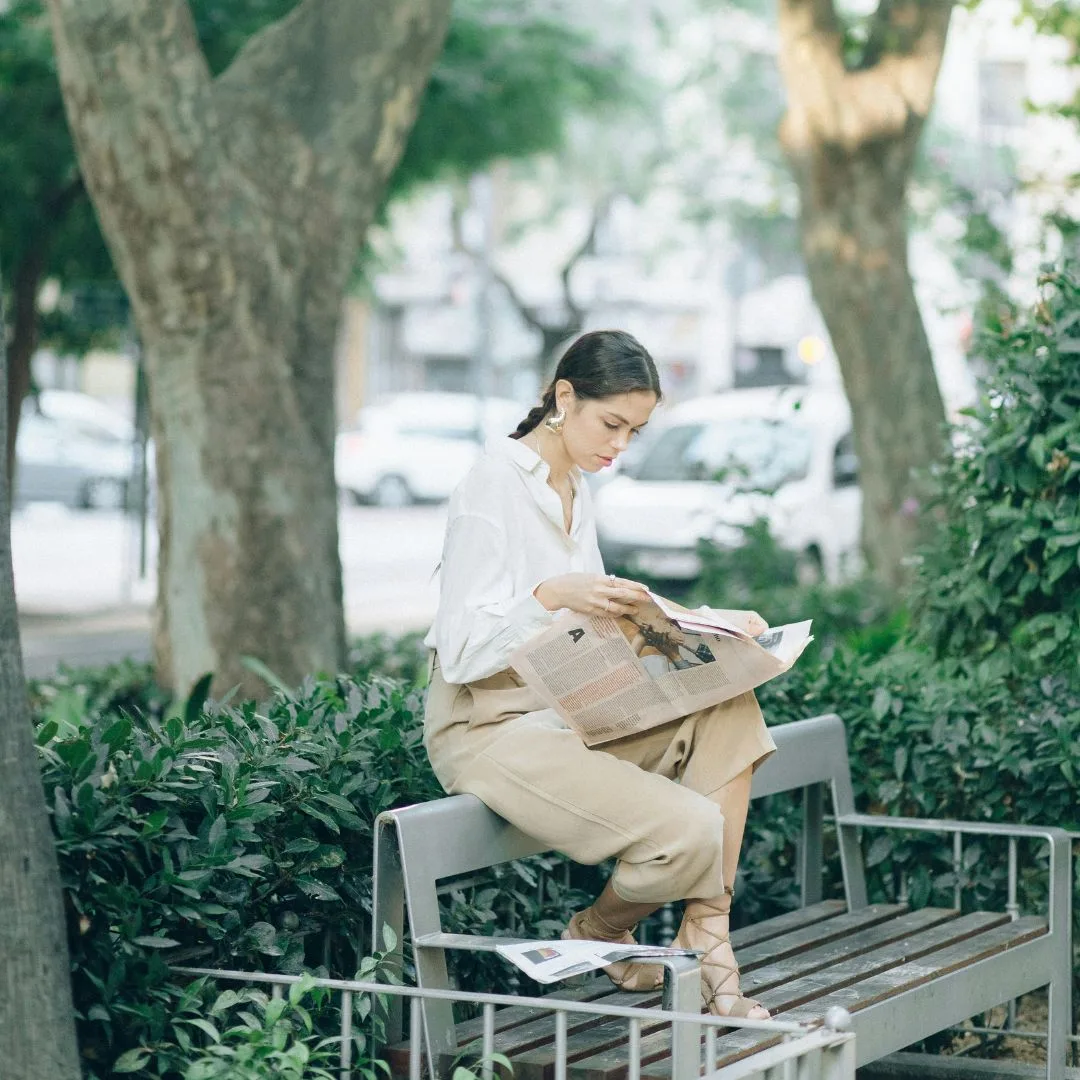 cô gái ngồi trên ghế đọc báo tử vi ngày 28/1/2026