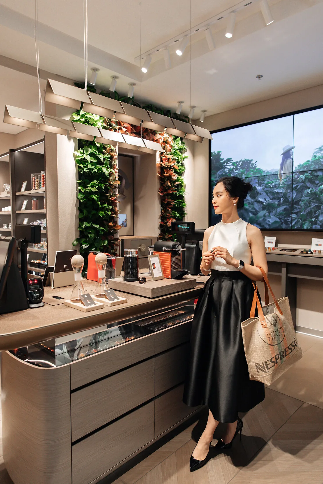 mc quỳnh nga bên cạnh quầy cà phê nespresso