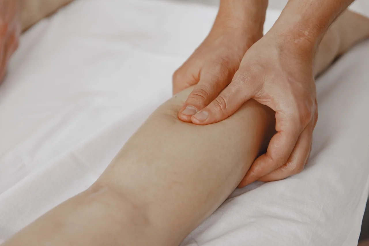 đang massage chân bị chuột rút do thiếu magie
