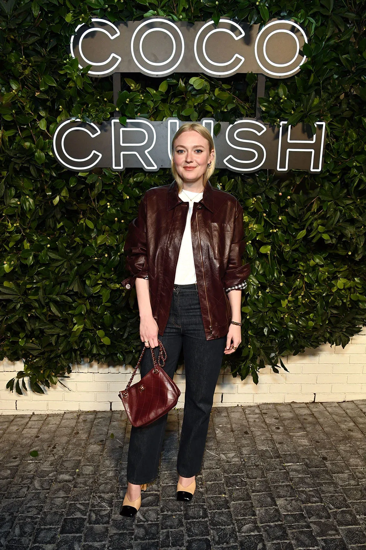 Dakota Fanning gây bất ngờ khi làm mới phong cách tối giản quen thuộc bằng chiếc áo khoác da Chanel tông đỏ burgundy sang trọng. (Ảnh: Chanel)