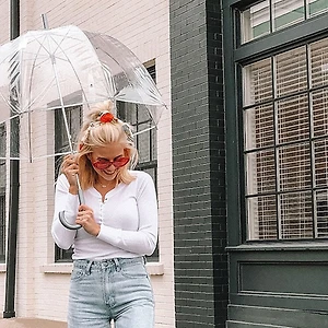 bảo quản quần áo mùa mưa cô gái cầm ô đứng dưới mưa - feature