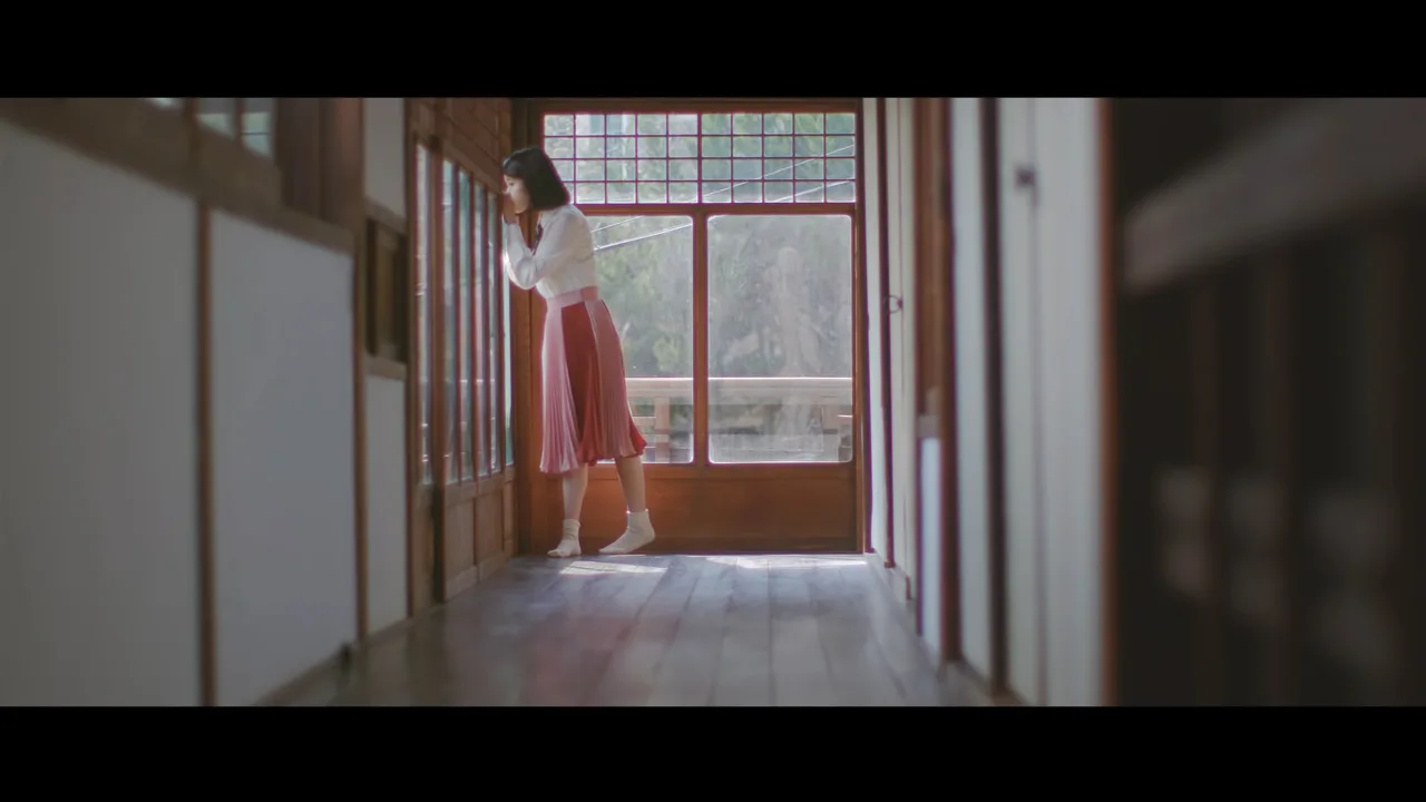 ca sĩ IU mặc áo sơ mi trắng và chân váy xếp ly trong MV Through The Night