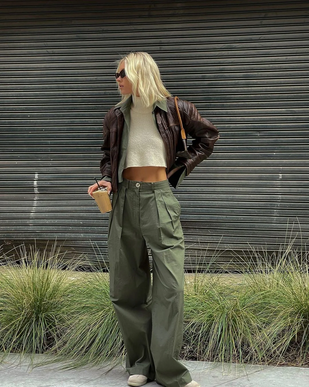 Quần ống rộng xanh rêu như một điểm "neo" mắt của outfit.