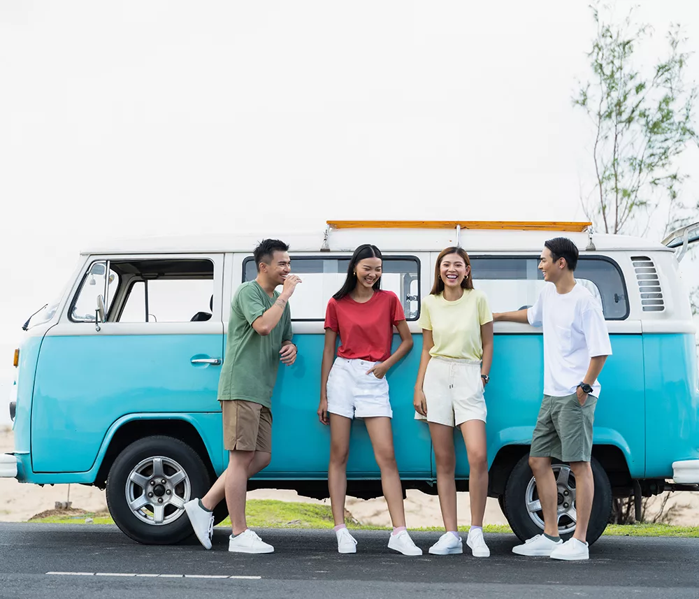 bốn người bạn vui vười bên cạnh xe van du lịch mùa hè