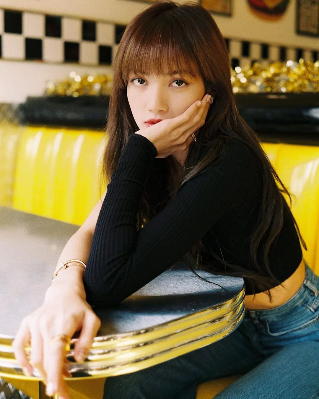 lisa blackpink mặc áo lệch vai đen đeo trang sức vòng tay bulgari