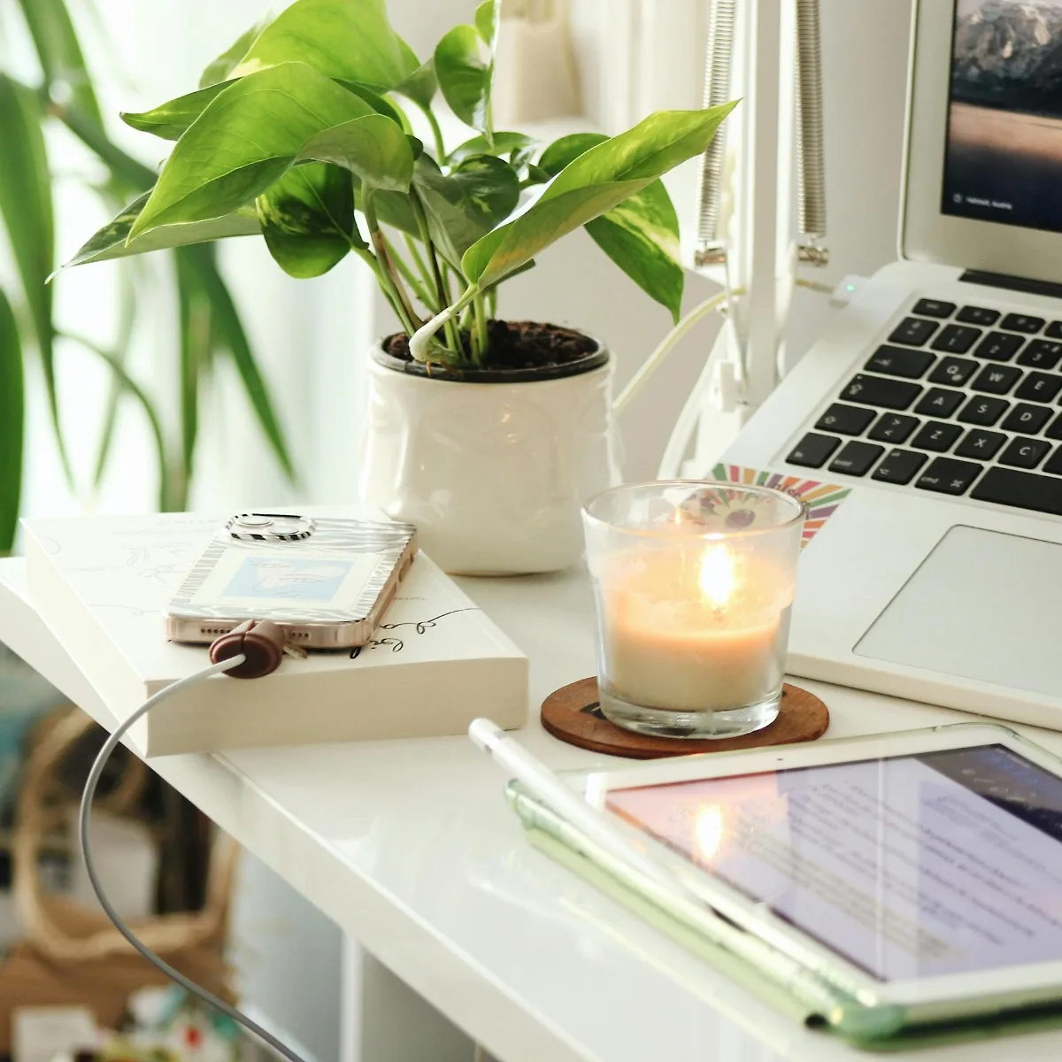 Bàn làm việc điện tử đặt nến thơm và chậu cây xanh