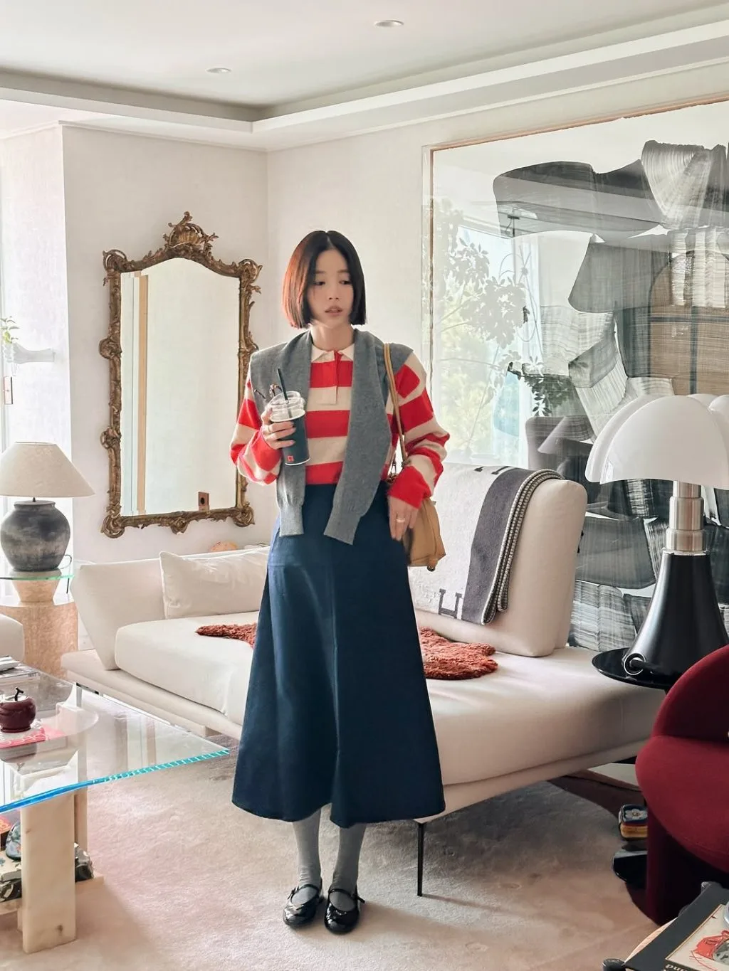 Lớp áo cardigan mỏng được phối tinh tế với áo polo dài tay, gợi nét ấm áp và hiện đại.