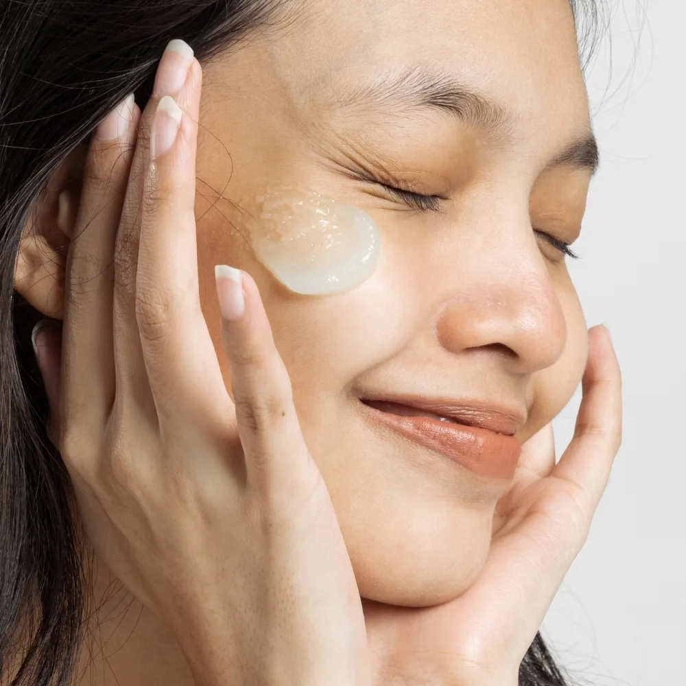 cô gái đưa tay lên mặt dưỡng da