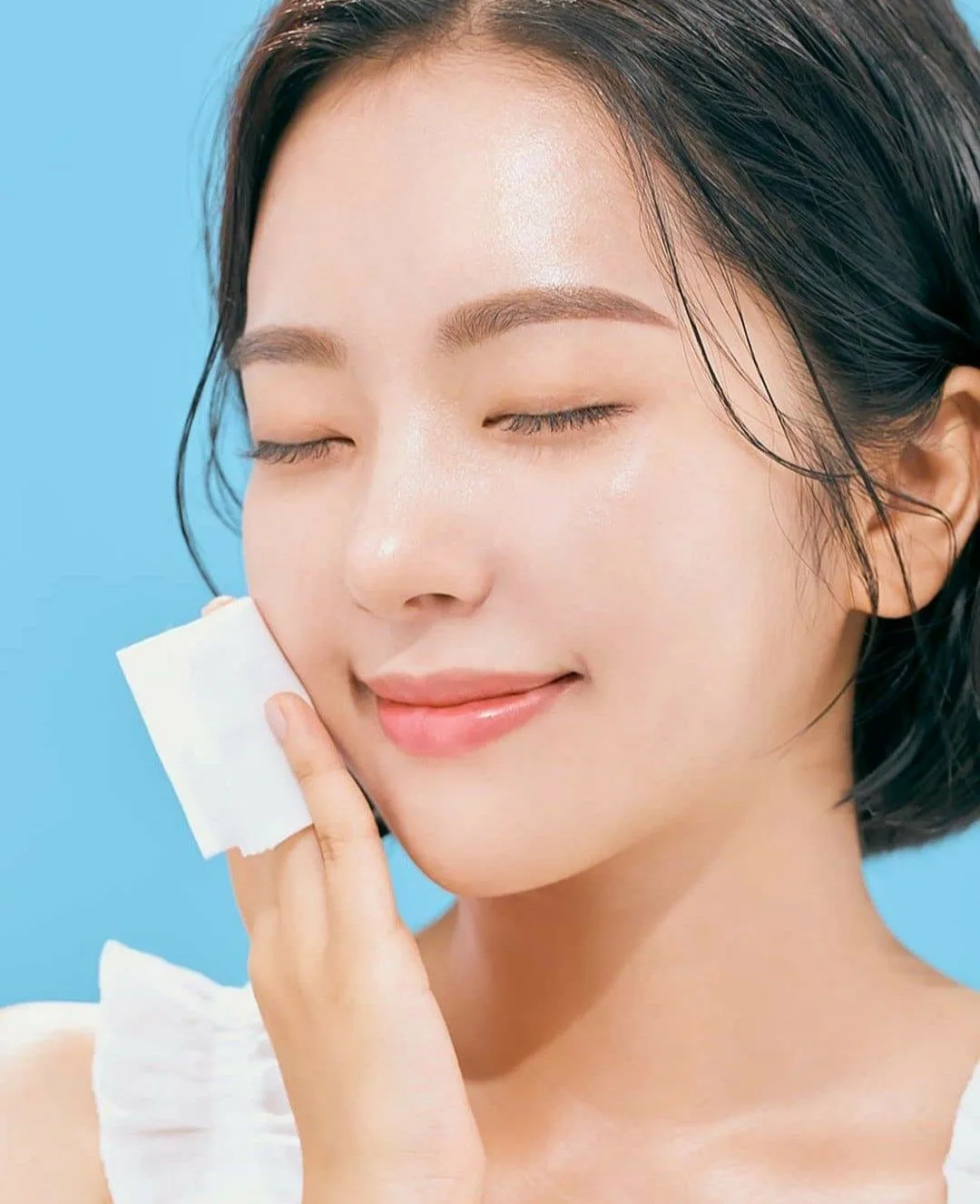 cô gái dùng giấy thấm dầu, lỗ chân lông