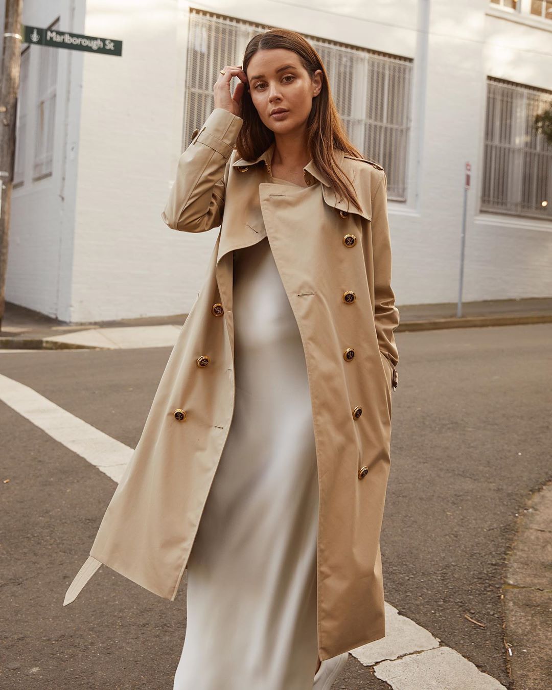 sara crampton mặc áo trench coat và đầm trắng