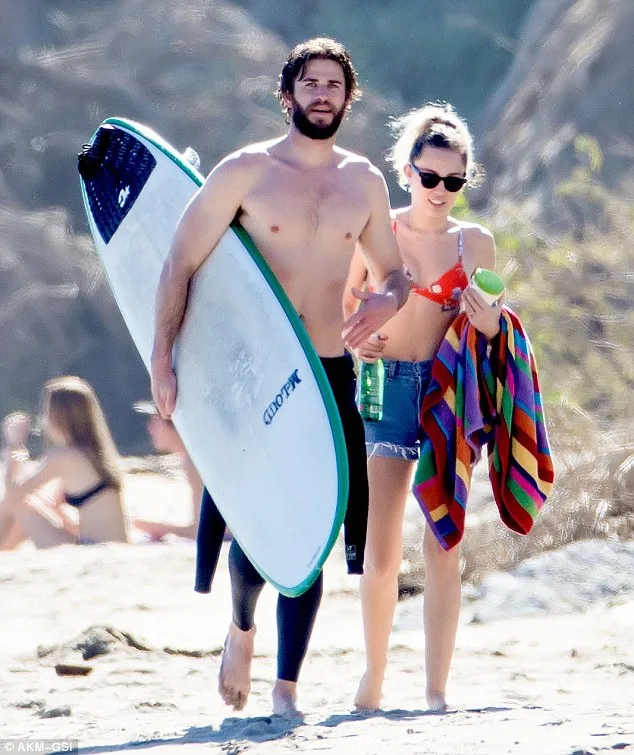 Mẹ Miley Cyrus lấp lửng về việc đính hôn của con gái Miley Cyrus và Liam Hemsworth tay trong tay tại một bờ biển tại Malibu
