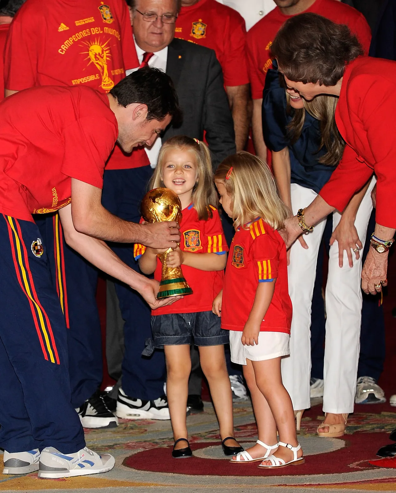 thủ môn kiêm đội trưởng người Tây Ban Nha Iker Casillas cầm chiếc cúp vô địch thế giới và cho công chúa nhỏ Leonor và Sofia