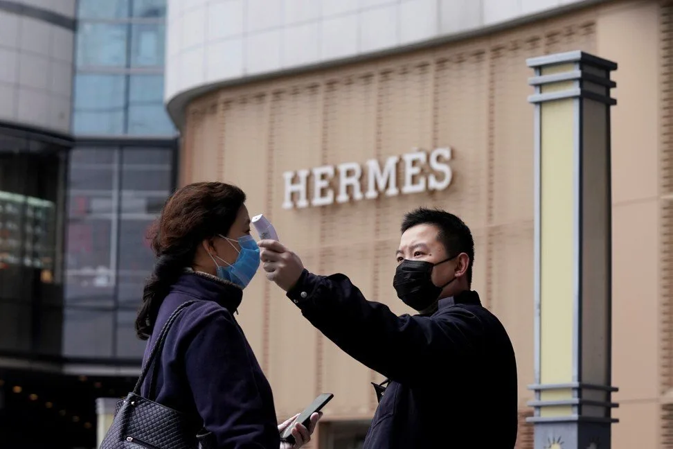 trong dịch covid-19 khách hàng được kiểm tra thân nhiêt trước khi vào cửa hàng hermes