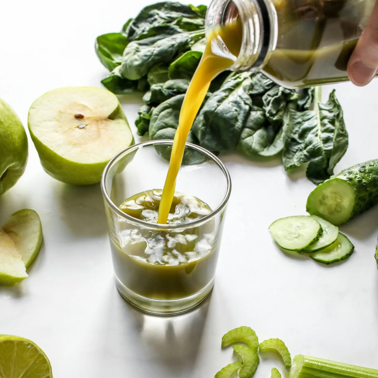 Hình ảnh nước ép cần tây được đổ từ chai vào ly.