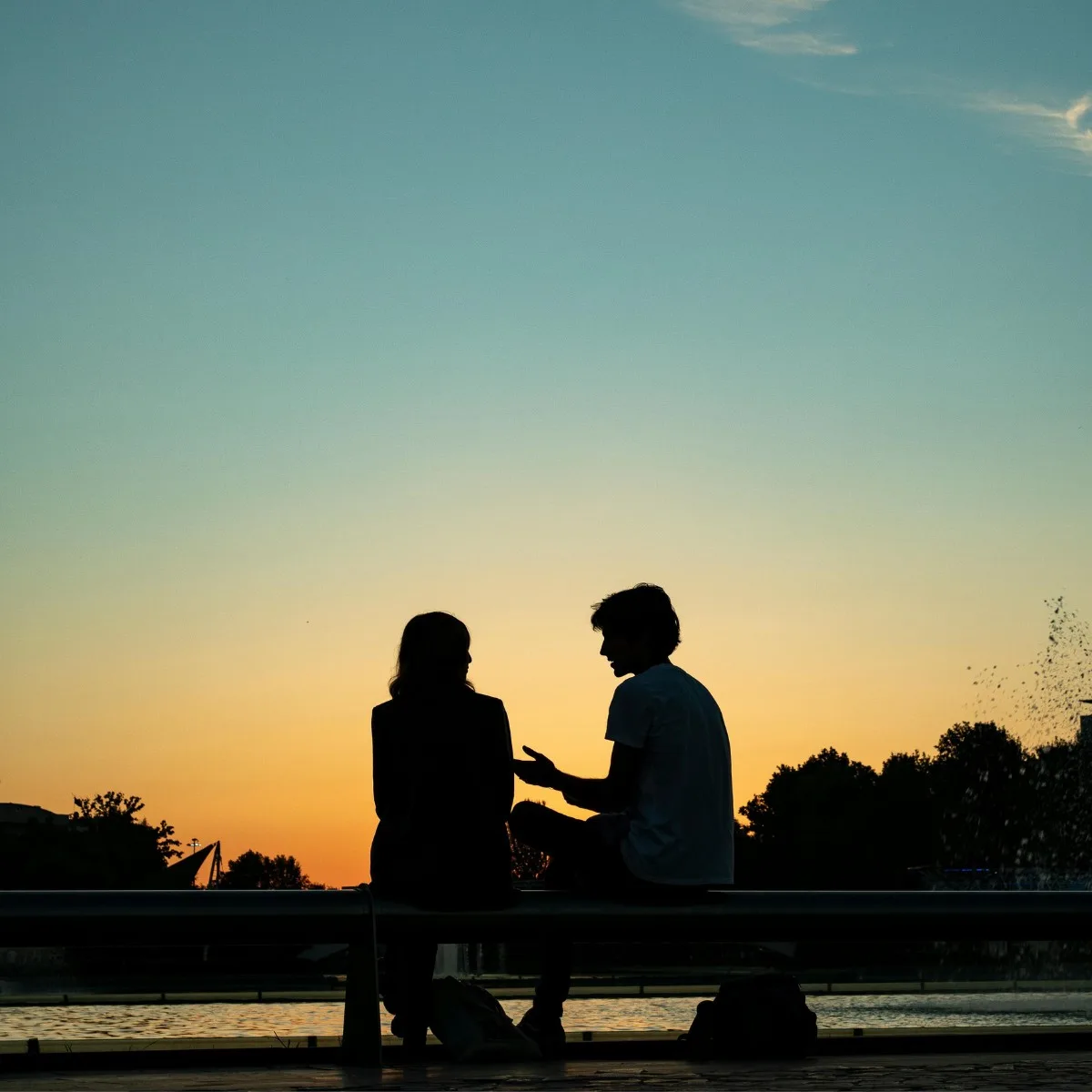 Cặp đôi ngồi trò chuyện với nhau lúc hoàng hôn theo cung hoàng đạo