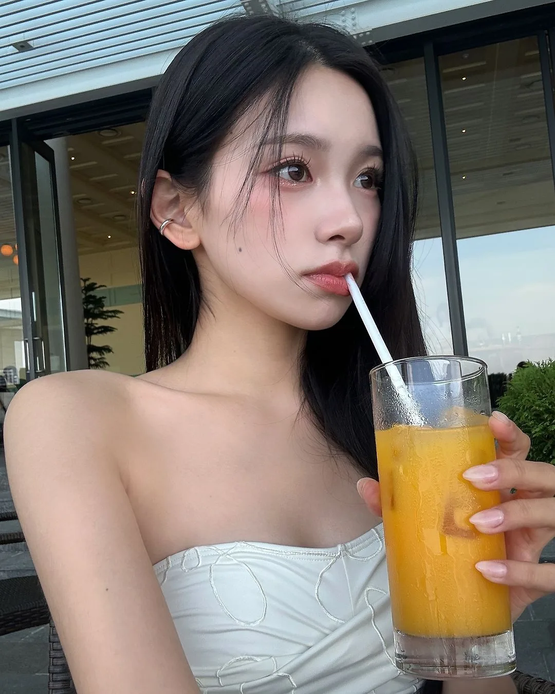 cô gái Hàn Quốc mặc áo corset màu trắng và uống nước cam để giảm cân
