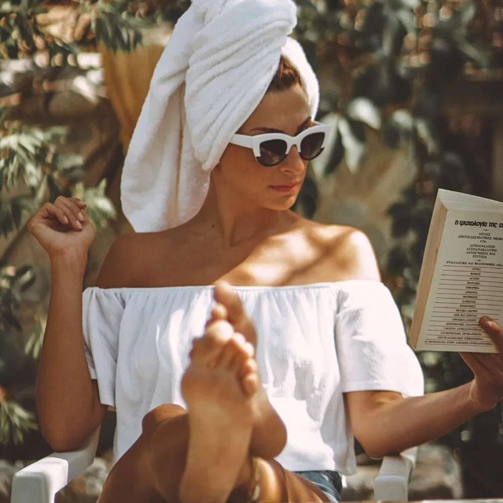 cô gái quấn khăn đầu ngồi dưới nắng để hấp thụ vitamin d