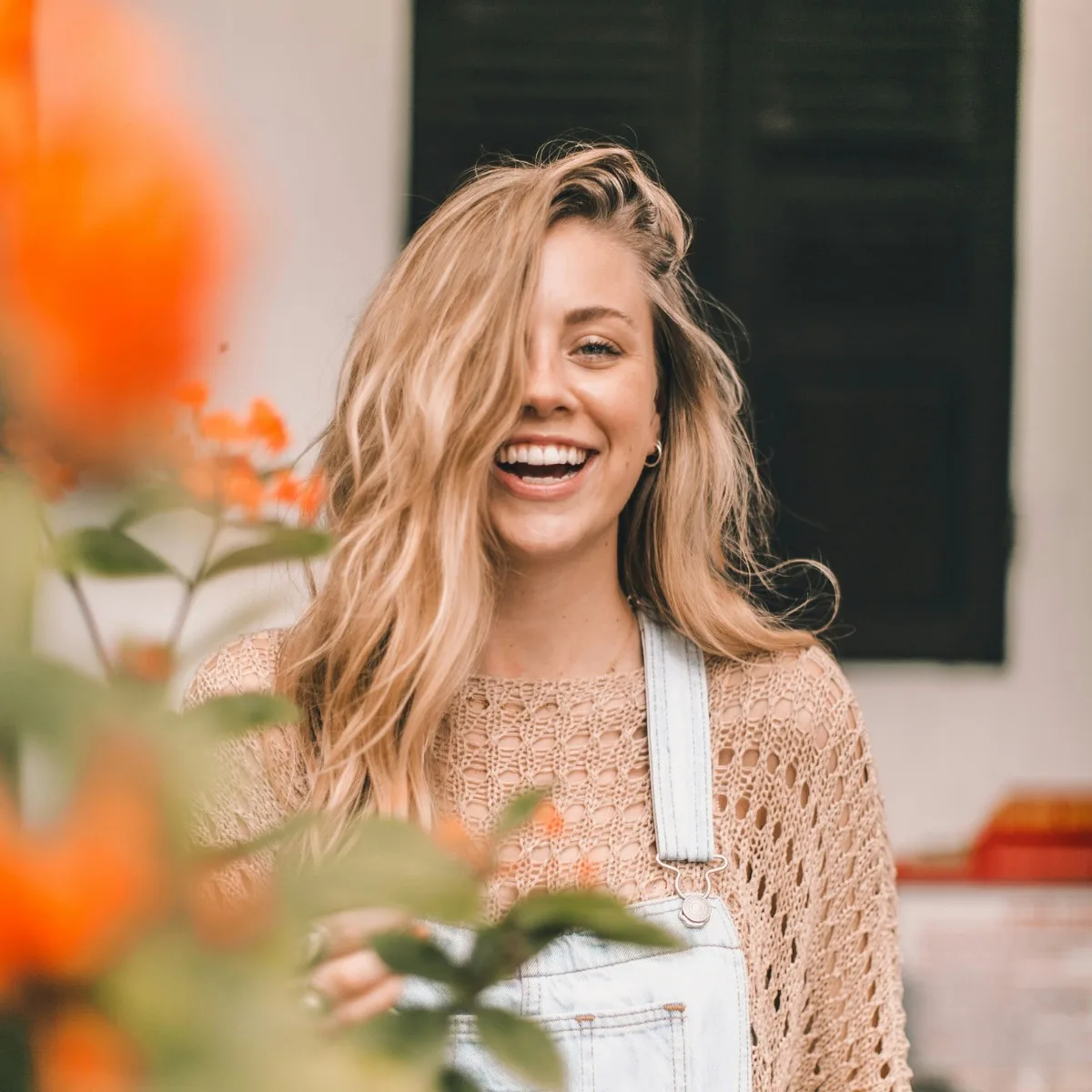 Cô gái tóc vàng mặc yếm jean cười hạnh phúc ngoài vườn hoa sau chia tay