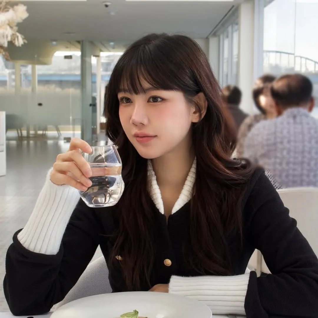 cô gái đang uông nước trong nhà hàng