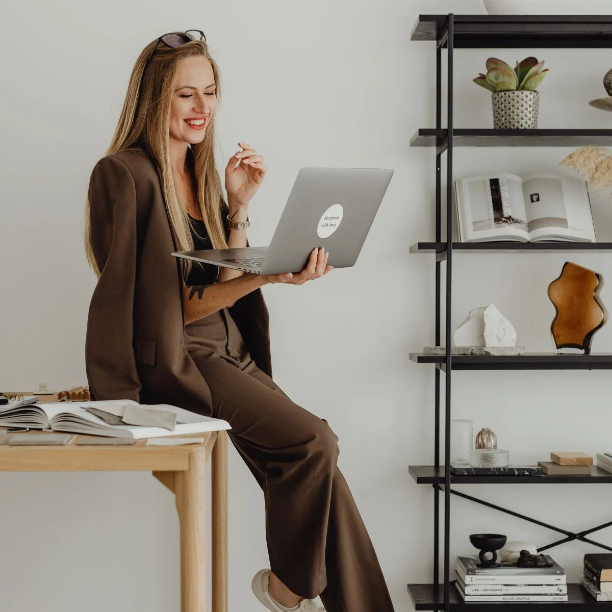 Cô gái tóc vàng ôm laptop ngồi dựa vào bàn định hình thương hiệu cá nhân