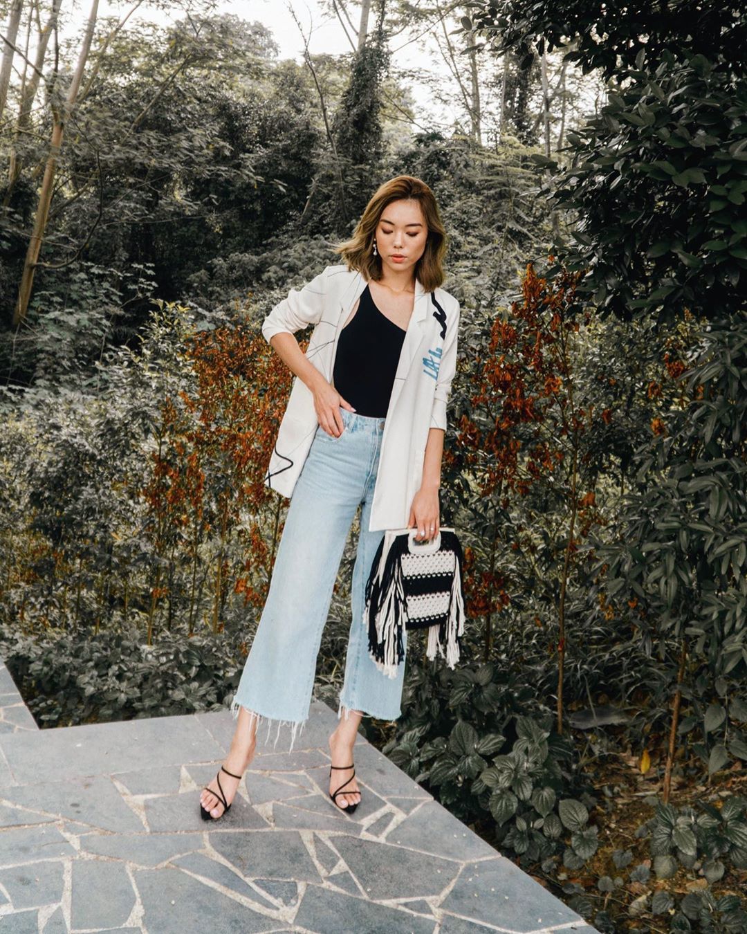 Fashionista mặc quần jeans ống rộng và áo tank top đen
