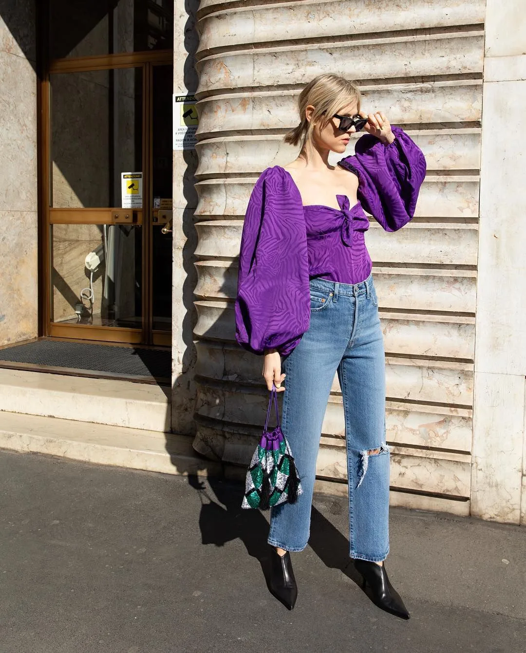fashionista diện áo blouse tông màu tím cùng quần jeans, bốt cổ thấp và túi xách cùng tông