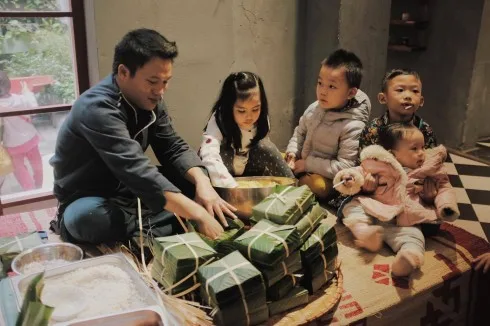 Trẻ con háo hức đón Tết bên mâm bánh chưng xanh truyền thống.