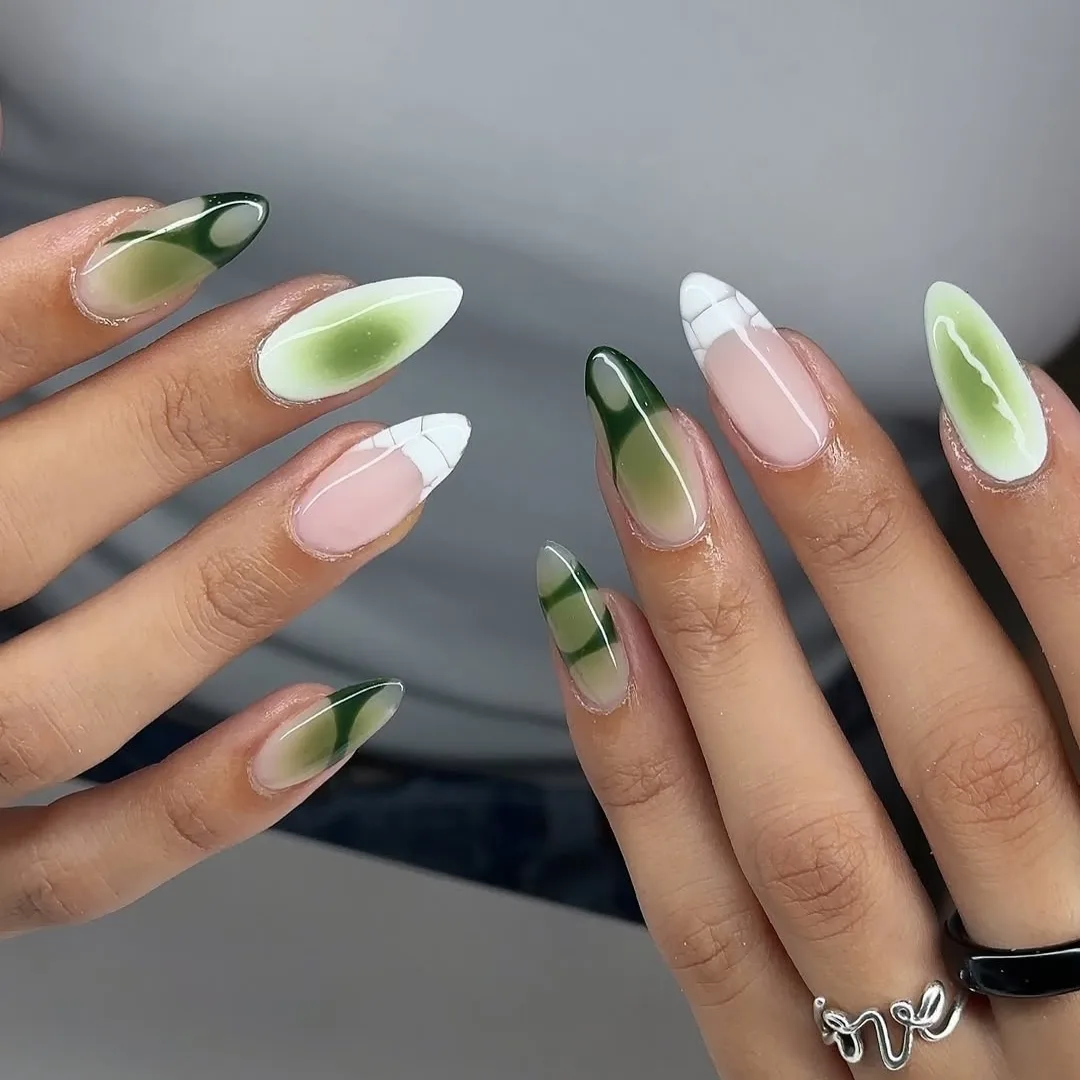 Hình ảnh kiểu móng lạ mắt với gam màu trắng, xanh lá chủ đạo, kết hợp với các hiệu ứng loang màu.