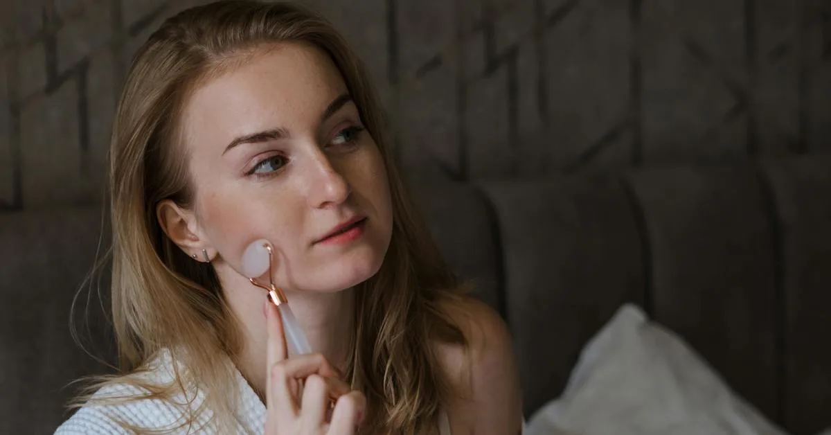 Cô gái sử dụng dụng cụ massage mặt trong chu trình chăm sóc da ban đêm