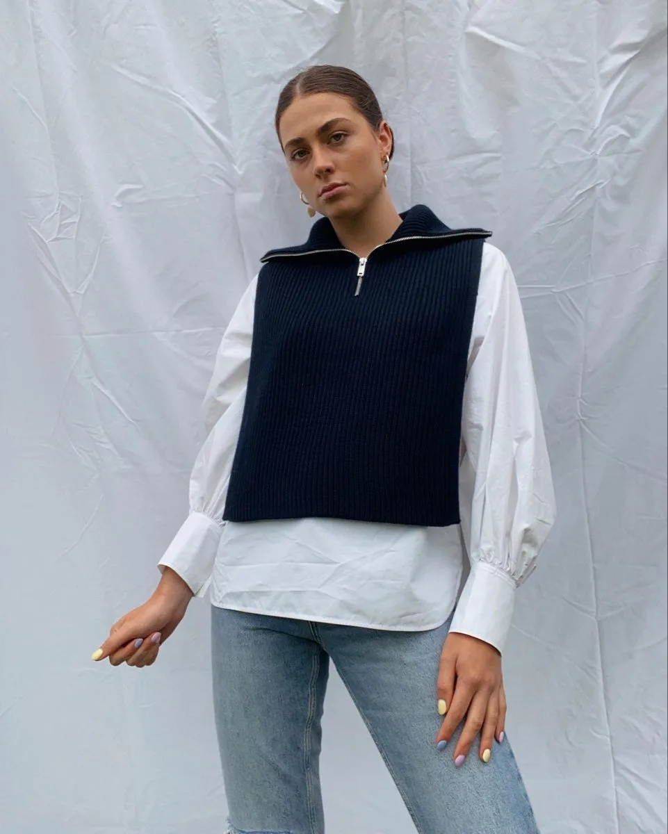 Áo len cổ khóa kéo và quần jeans nhạt trẻ trung dạo phố.