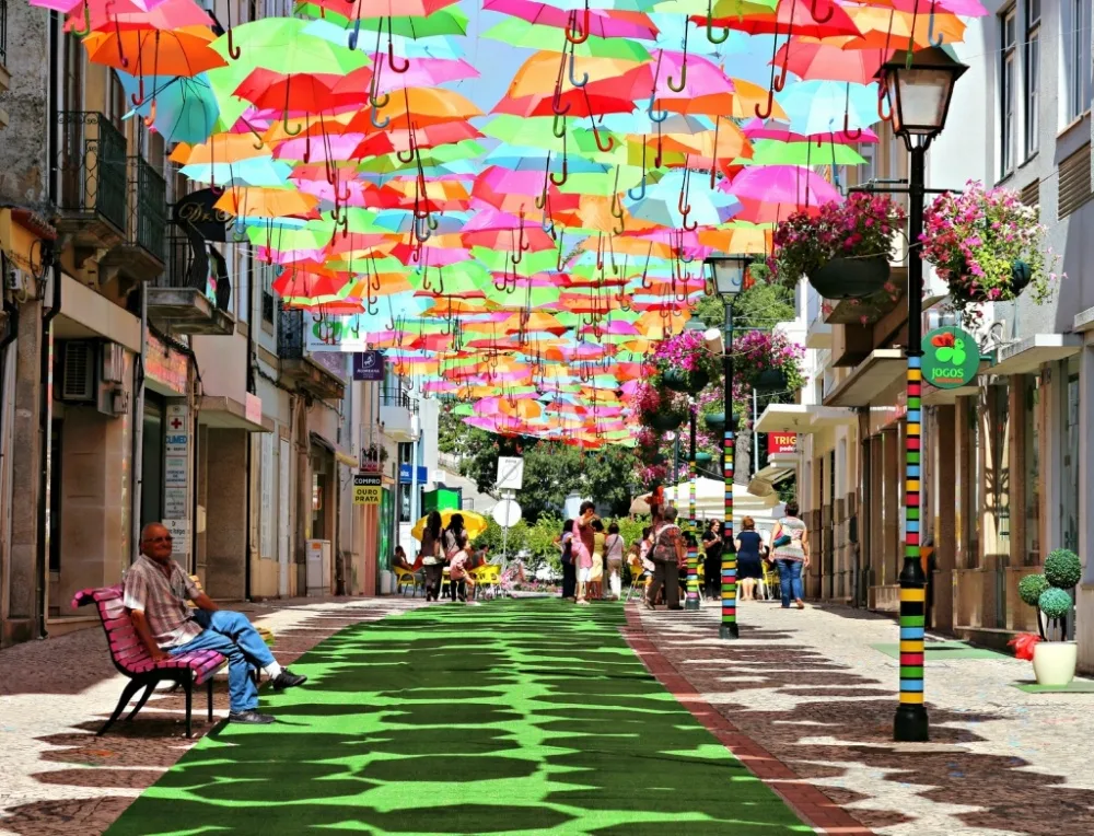 9 con đường đẹp chỉ có ở chốn thần tiên Những chiếc dù này lần đầu xuất hiện tại Agueda vào năm 2012. Những chiếc dù màu sắc này được trang trí cũng như giúp người đi bộ tránh khỏi cái nắng gắt ở Bồ Đào Nha.