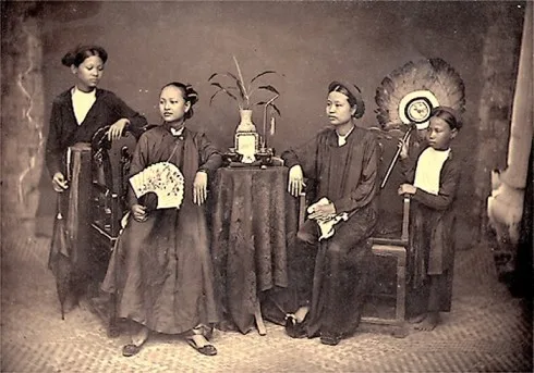 Ảnh cho thấy sự phân biệt tầng lớp trong một gia đình, chủ mặc áo ngũ thân, người hầu mặc áo tứ thân (1884-1885)
