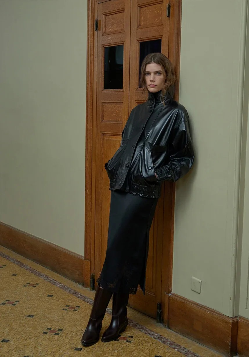 Look 2 áo khoác da và chân váy satin đen