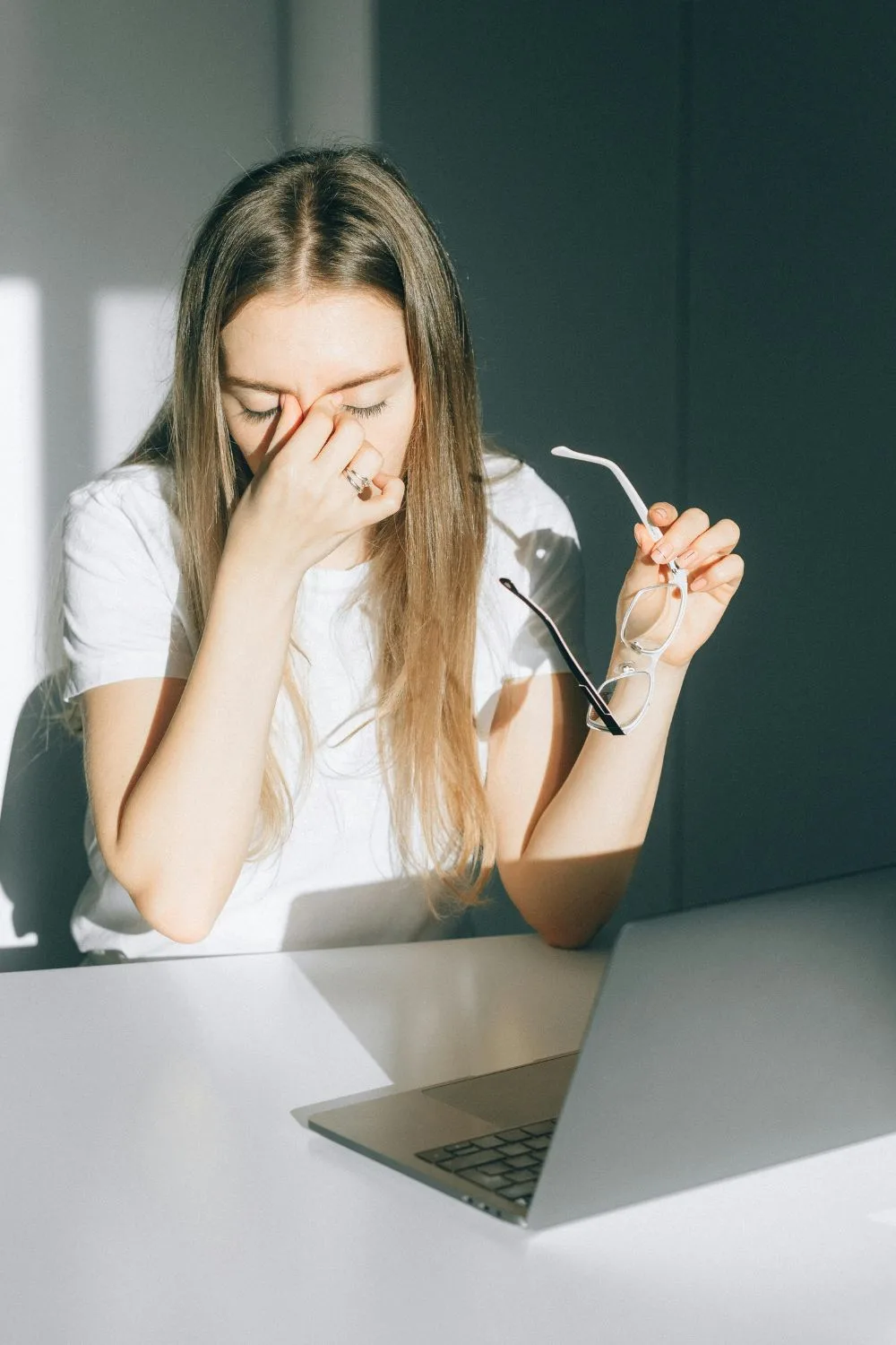 cô gái mỏi mắt do làm việc bằng máy tính lâu