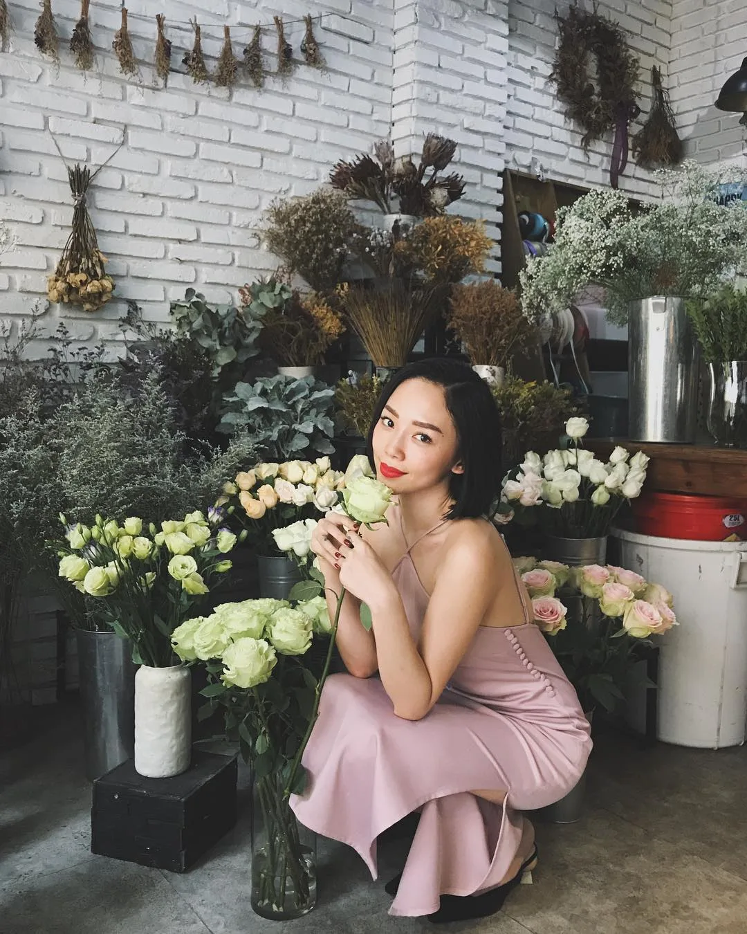 tóc tiên mặc đầm slip dress lụa cổ yếm màu hồng thạch anh rose quartz trong tiệm hoa