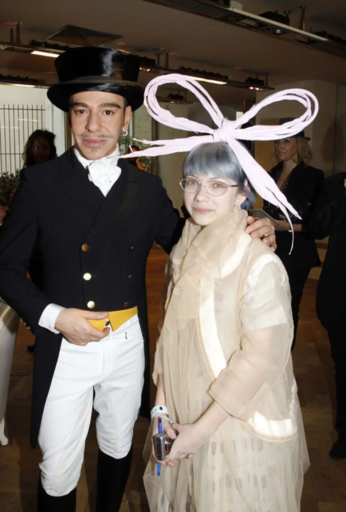 Ảnh: NTK John Galliano và Tavi Gevinson với chiếc nơ gây tranh cãi (Ảnh: Getty Images)