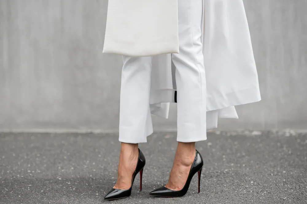 Fashionista mặc quần trắng đi giày cao gót đen