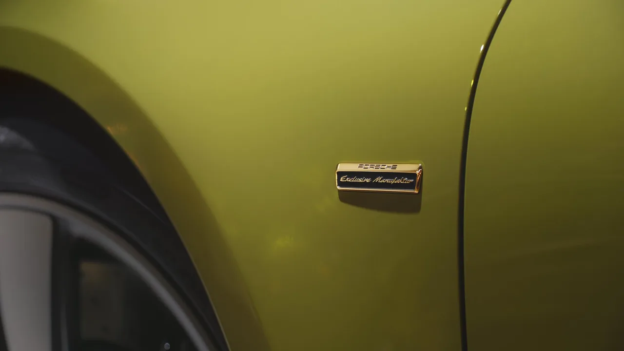 Hai tấm ốp chắn bánh xe trước được đính huy hiệu “Porsche Exclusive Manufaktur” màu vàng ánh kim.